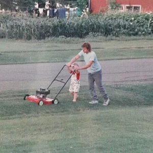dad and kid mowing grass